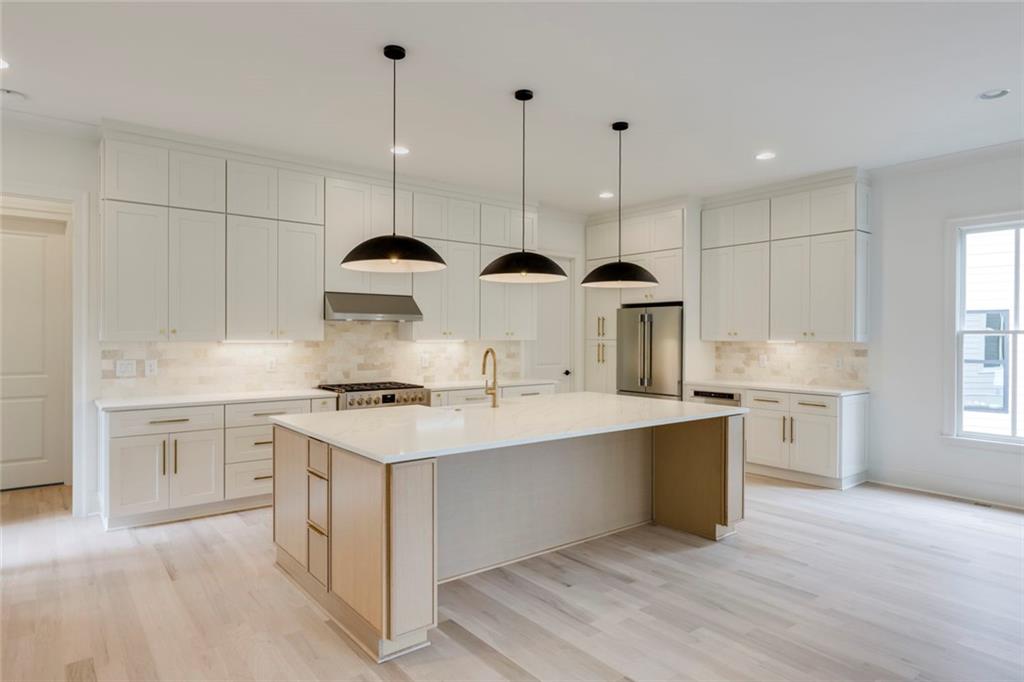 551 Sunset Drive Norcross, GA 30071 - Photo 8 of 45 a kitchen with stainless steel appliances granite countertop a sink a stove a refrigerator and island with wooden floor