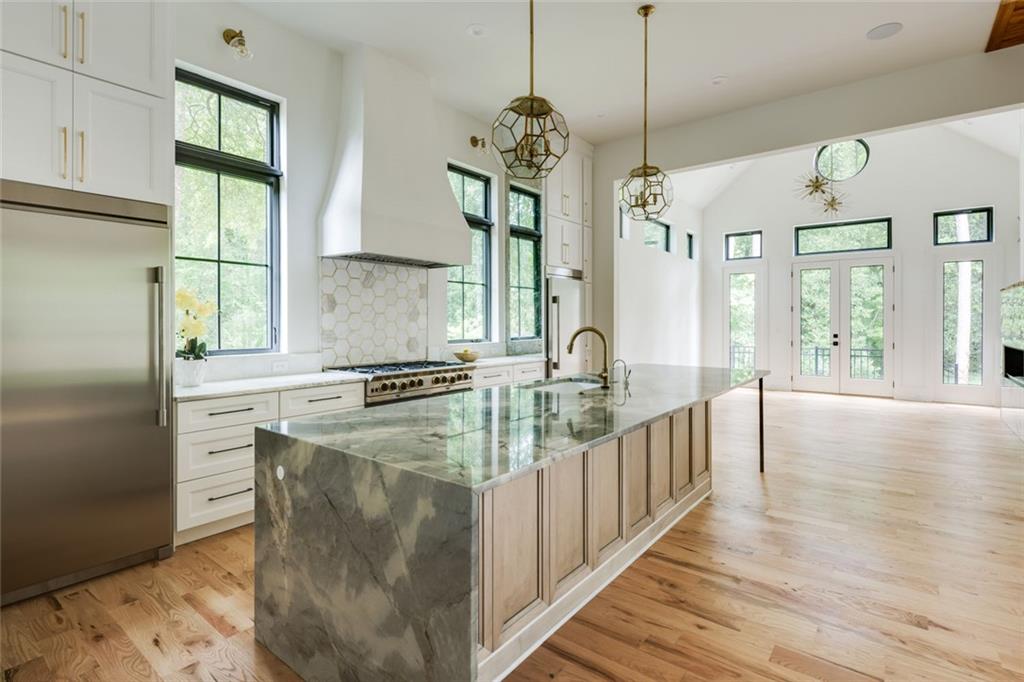 551 Sunset Drive Norcross, GA 30071 - Photo 9 of 45 a kitchen with stainless steel appliances granite countertop a sink a stove and a wooden floors