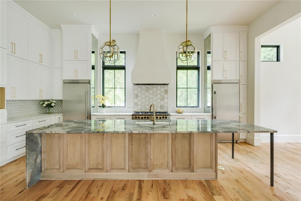 551 Sunset Drive Norcross, GA 30071 - Photo 10 of 45 a kitchen with kitchen island granite countertop a stove a sink and white cabinets with wooden floor