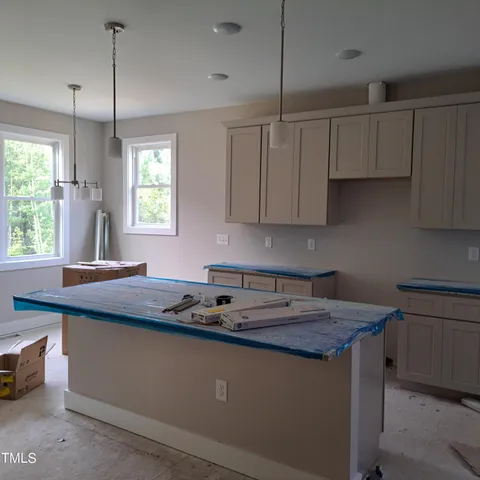 a kitchen with granite countertop a sink a stove and cabinets