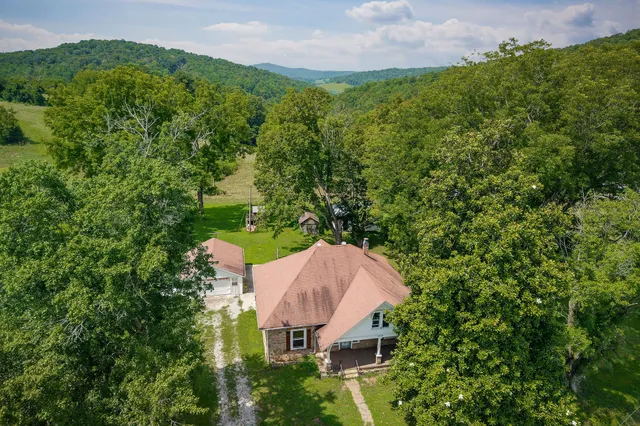 an aerial view of a house with a garden and trees