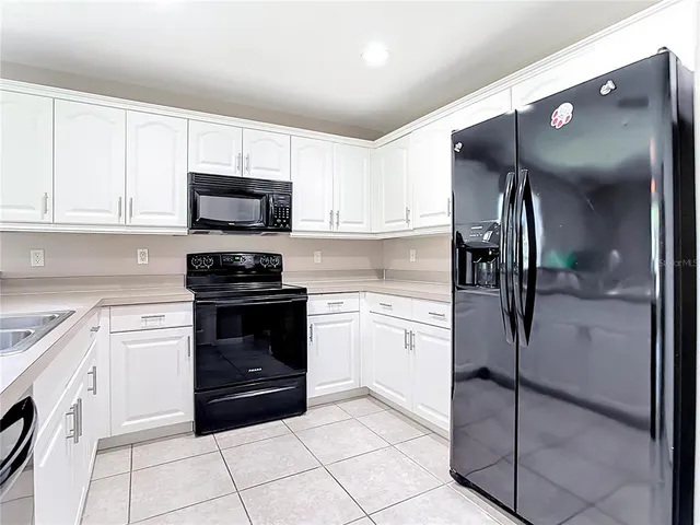 a bed sitting in a spacious bedroom next to a window