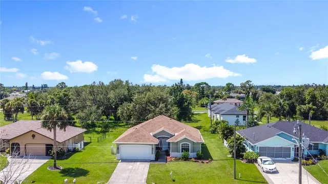 an aerial view of a house with swimming pool and a yard