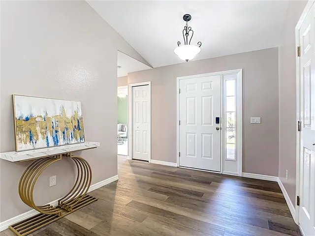a workspace with wooden floor a chandelier a wooden table and chairs