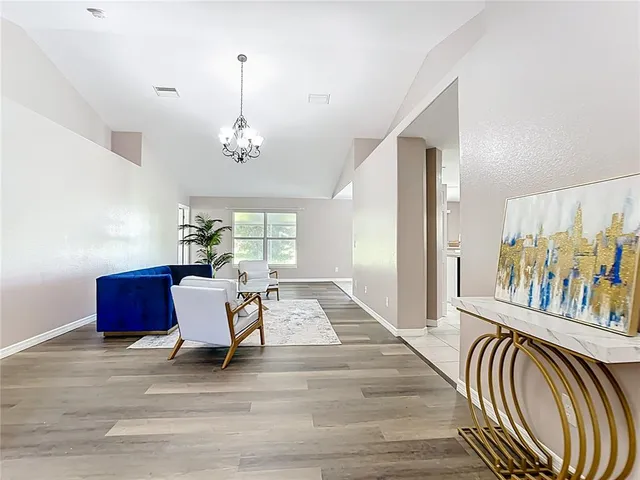 a living room with furniture and a chandelier