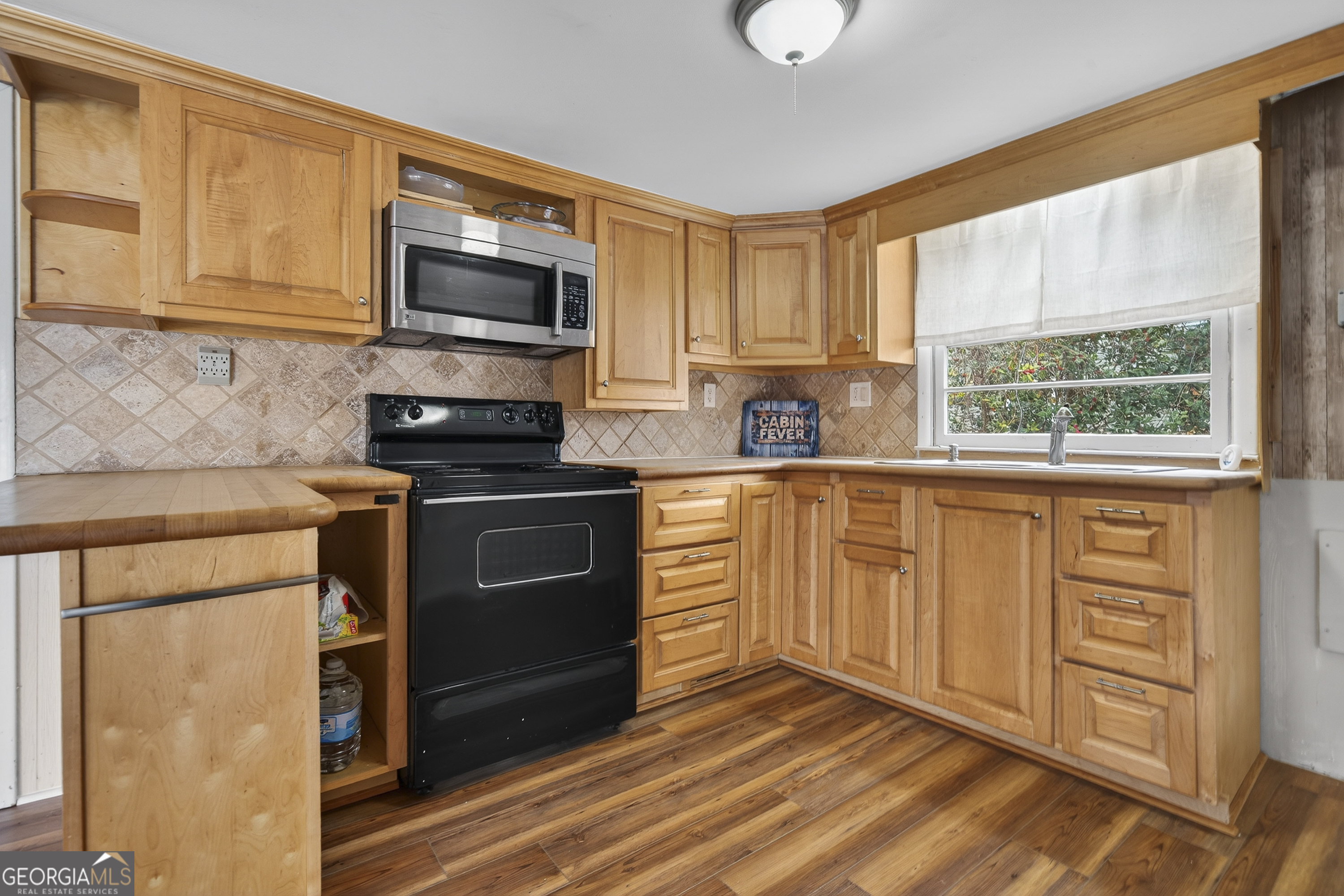 126 Elizabeth Circle Jackson, GA 30233 - Photo 7 of 41 a kitchen with granite countertop a stove a sink and a microwave