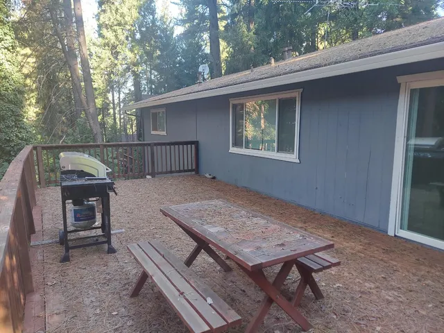 a view of backyard with deck and outdoor seating