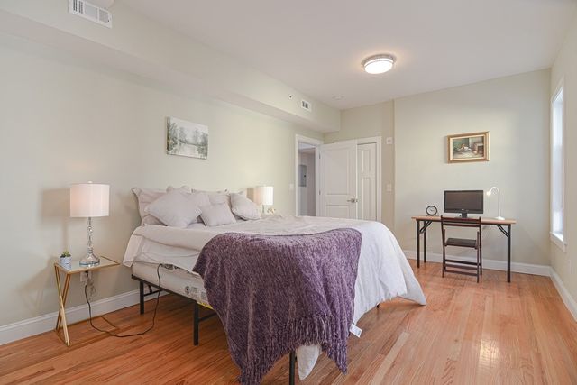 a spacious bedroom with a bed and a table in it