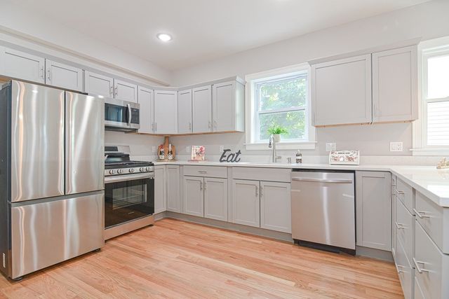 a kitchen with granite countertop a refrigerator sink and cabinets