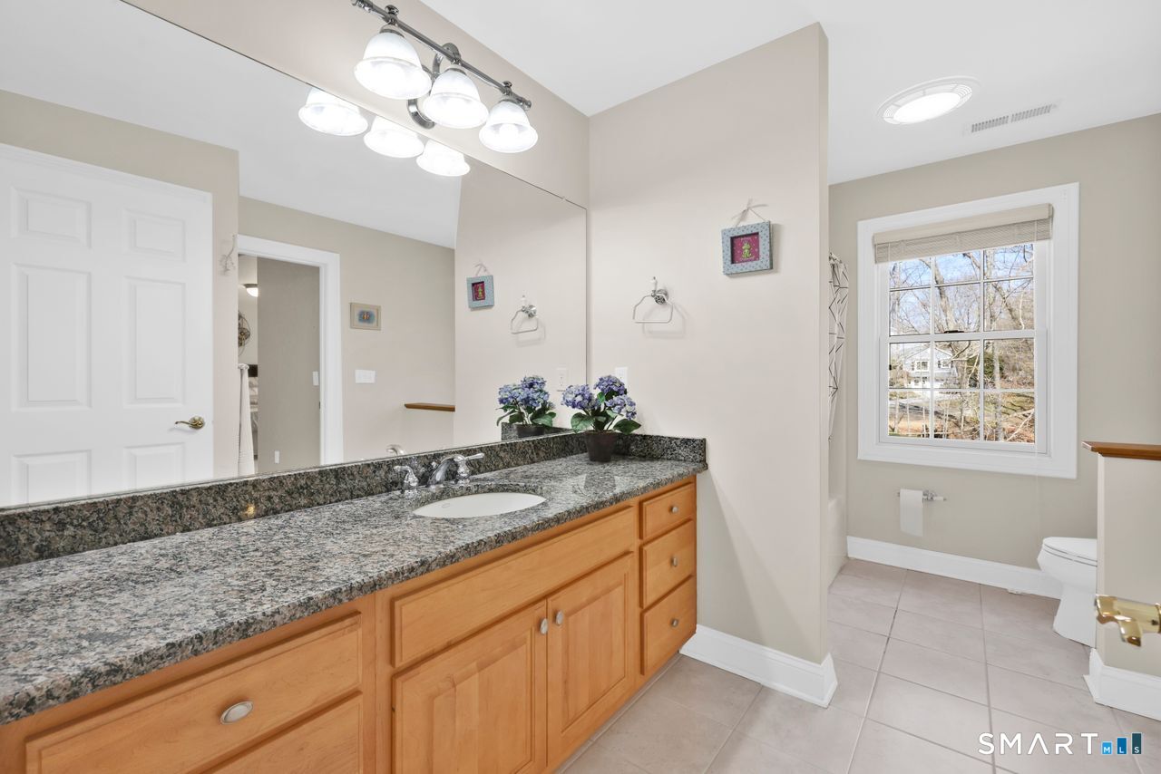 1 Bramble Trail Newtown, CT 06470 - Photo 22 of 31 a bathroom with a granite countertop sink a toilet and large mirror