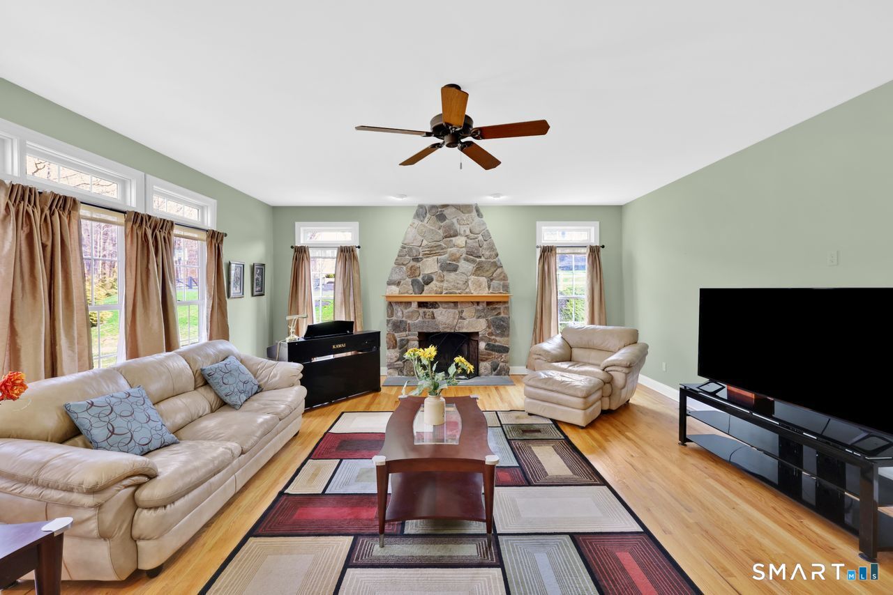 1 Bramble Trail Newtown, CT 06470 - Photo 10 of 31 a living room with furniture ceiling fan and a flat screen tv