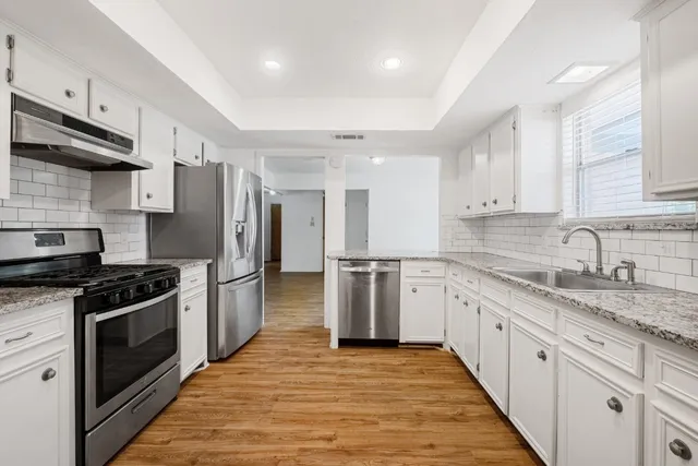 a kitchen with stainless steel appliances granite countertop a stove sink and refrigerator