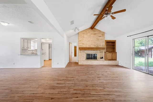 a view of empty room with wooden floor and fireplace
