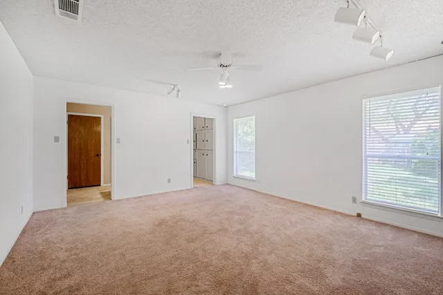 an empty room with windows and closet