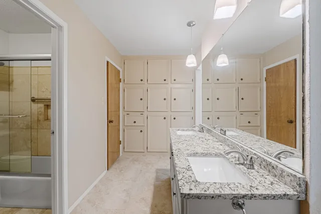 a spacious bathroom with a granite countertop sink mirror and shower