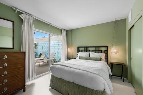 a bedroom with a bed and a large window