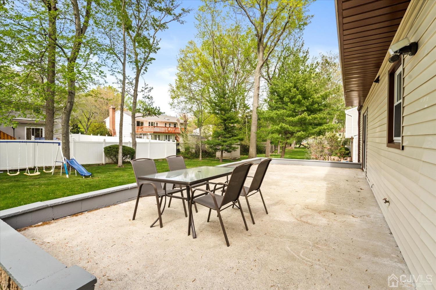 39 Lynnwood Road Edison, NJ 08820 - Photo 29 of 32 a view of a backyard with table and chairs and a barbeque with potted plants and large trees