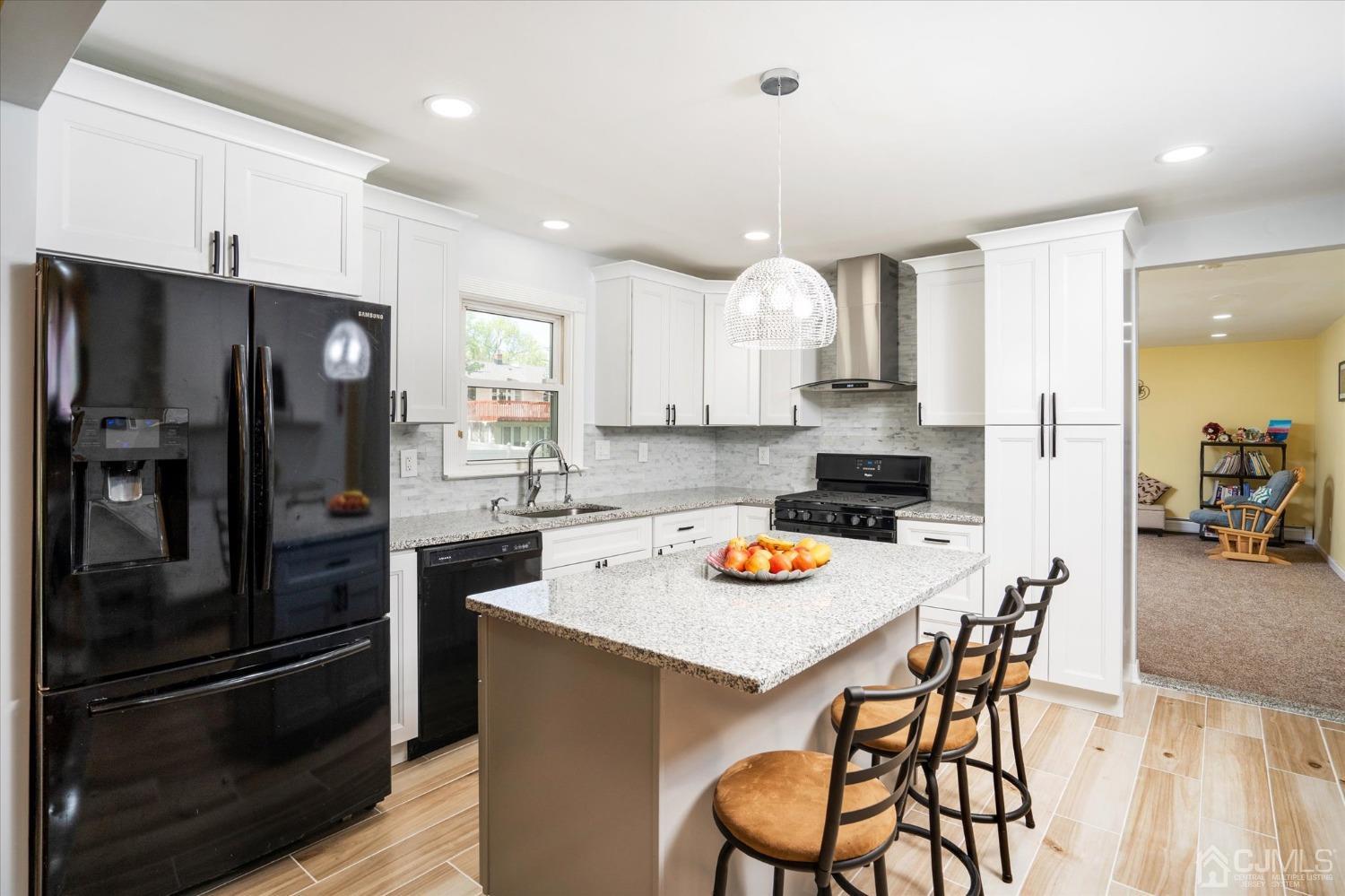 39 Lynnwood Road Edison, NJ 08820 - Photo 4 of 32 a kitchen with stainless steel appliances a refrigerator a stove a sink a dining table and chairs with wooden floor