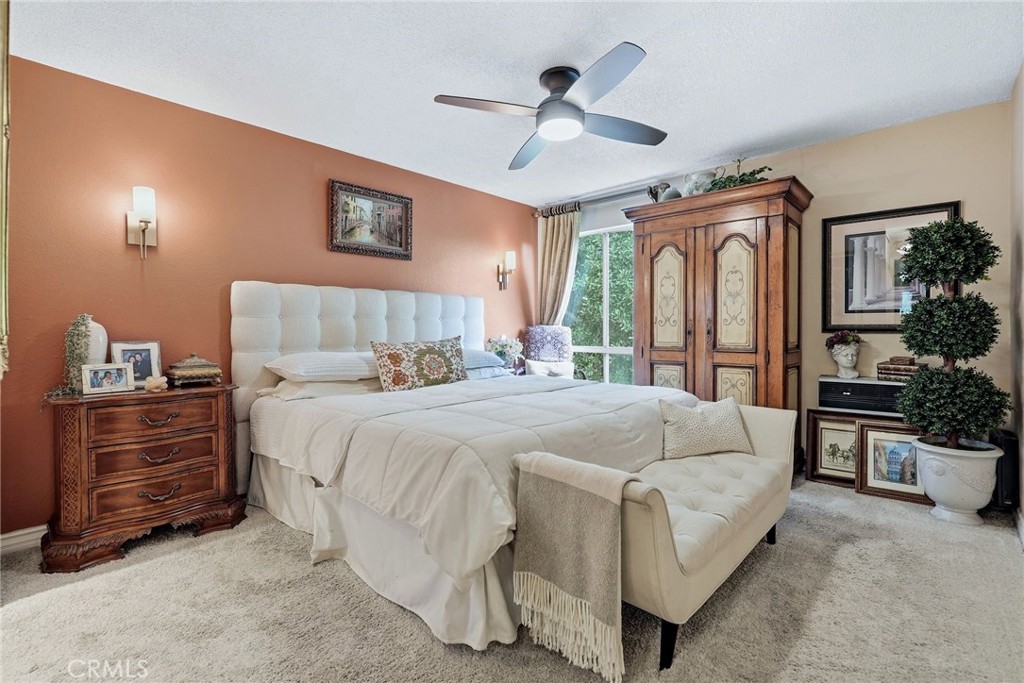 7890 East Spring Street, Unit 2L Long Beach, CA 90815 - Photo 20 of 47 a spacious bedroom with a bed a ceiling fan and a dresser