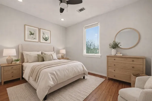 an empty room with wooden floor ceiling fan and window