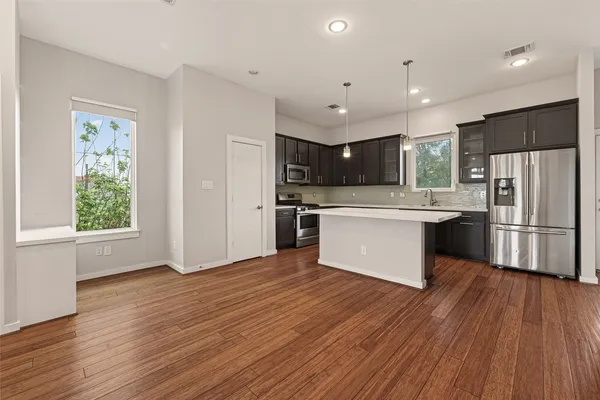 a kitchen with stainless steel appliances granite countertop a stove a sink and a refrigerator