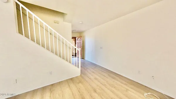 a view of a hallway with wooden floor and staircase