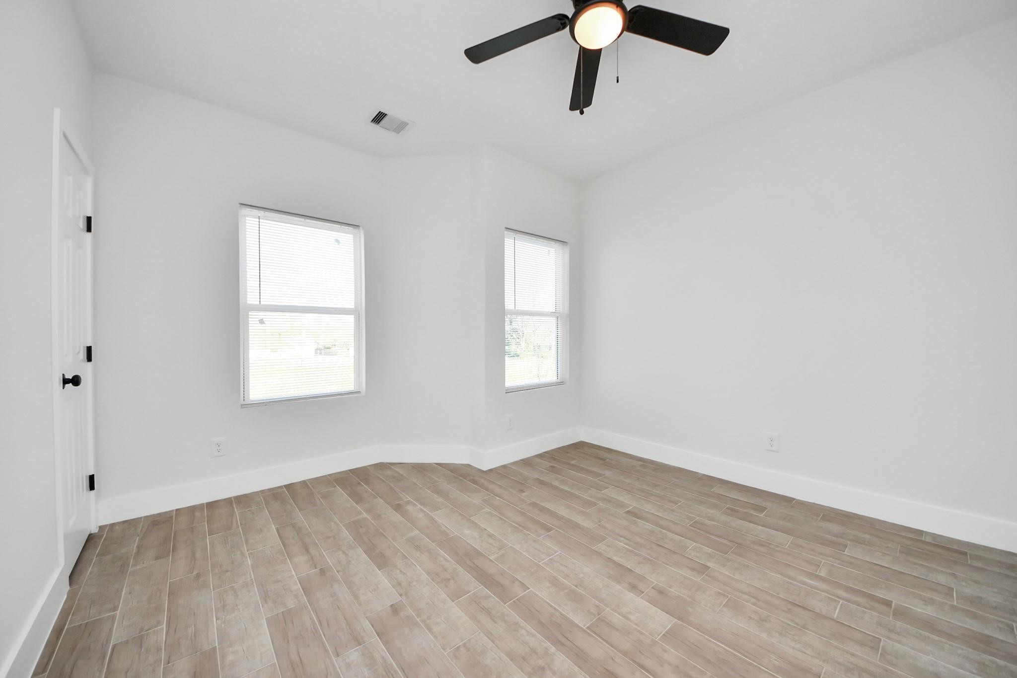 8015 Elbert Street, Unit A/B Houston, TX 77028 - Photo 7 of 12 an empty room with a window and a ceiling fan