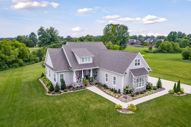 a aerial view of a house with a yard table and chairs