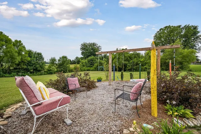 a view of a house with backyard sitting area and garden