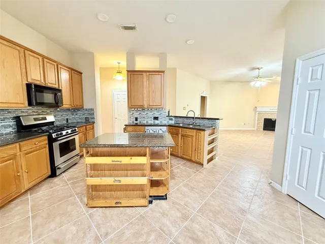 a large kitchen with kitchen island a stove a sink and a refrigerator