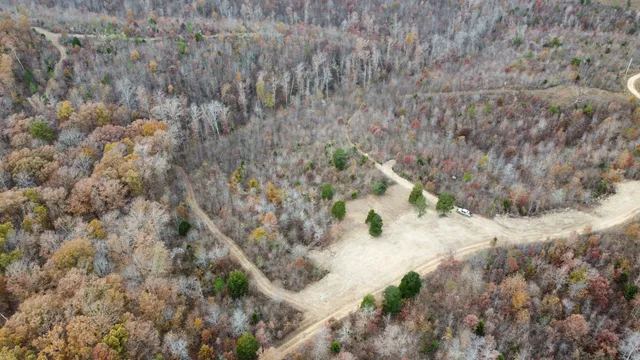 an aerial view of house with yard and mountain view in back