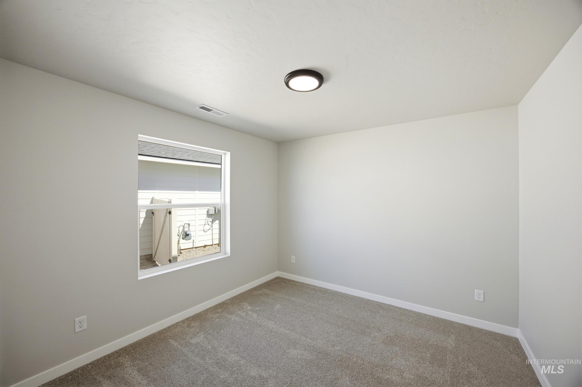 4344 East Rincon Drive Meridian, ID 83642 - Photo 16 of 26 Neutral wall paint, plush carpet flooring, white trim, single window, and a flush-mount ceiling light