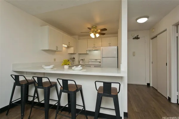 a kitchen with stainless steel appliances a dining table chairs and white cabinets
