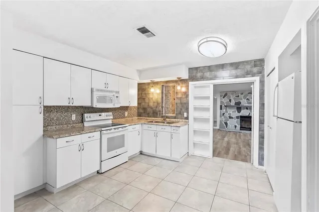 a kitchen with white cabinets and white appliances