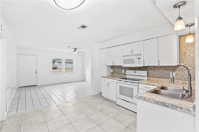 a kitchen with a sink a stove and cabinets