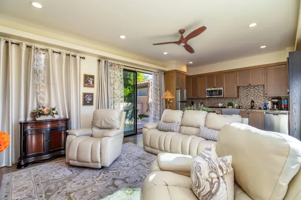 a living room with furniture kitchen area and a window