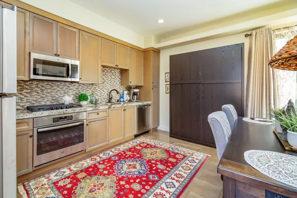 a kitchen with stainless steel appliances granite countertop a dining table and chair