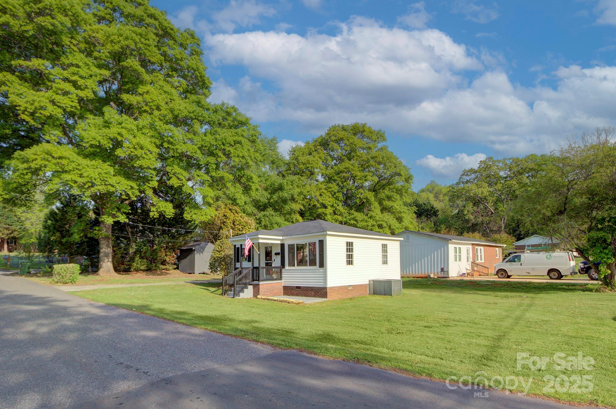 103 Moore Avenue Mount Holly, NC 28120 - Photo 20 of 21 a front view of a house with a garden and trees