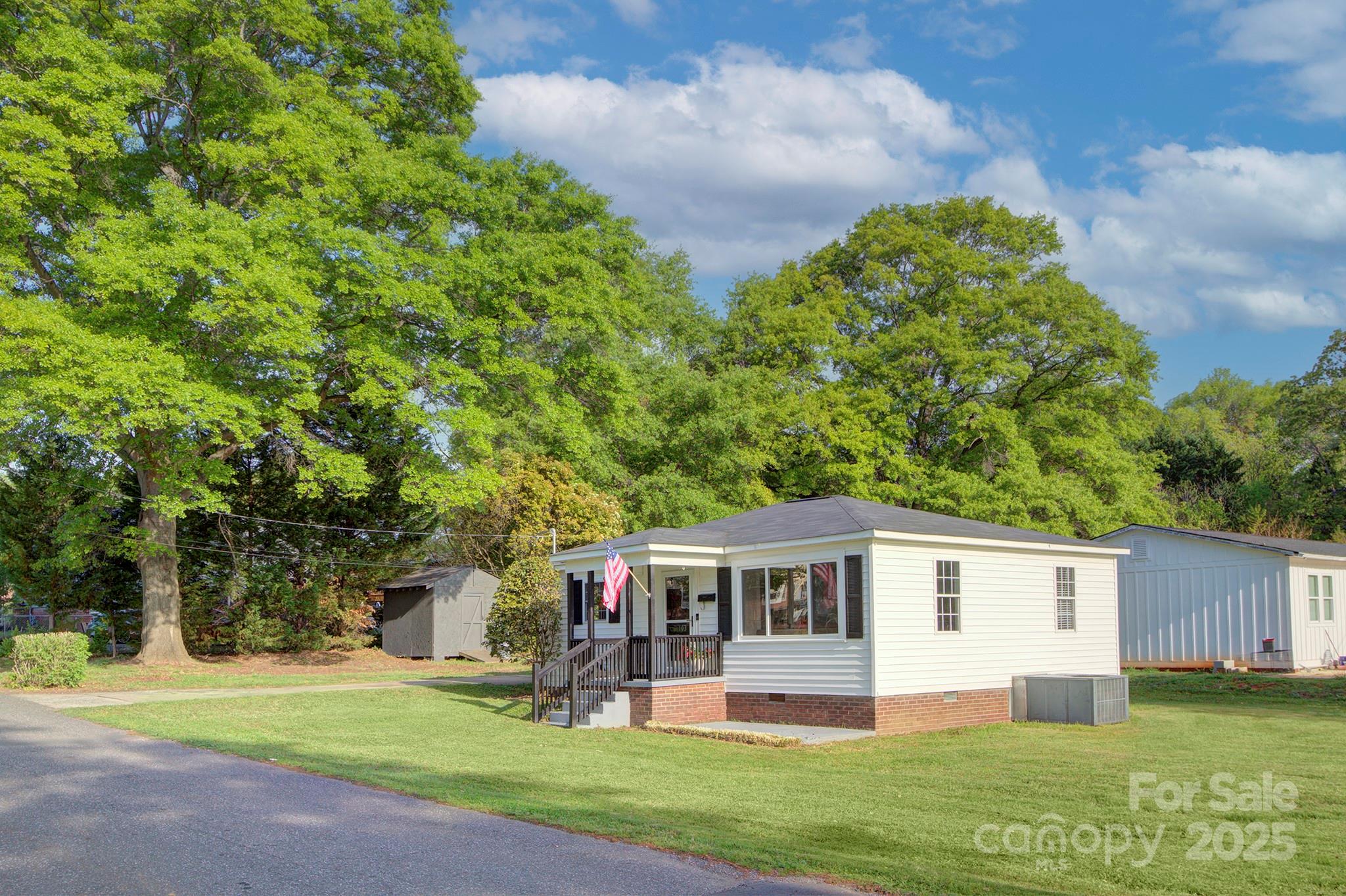 103 Moore Avenue Mount Holly, NC 28120 - Photo 21 of 21 a front view of a house with a garden and trees