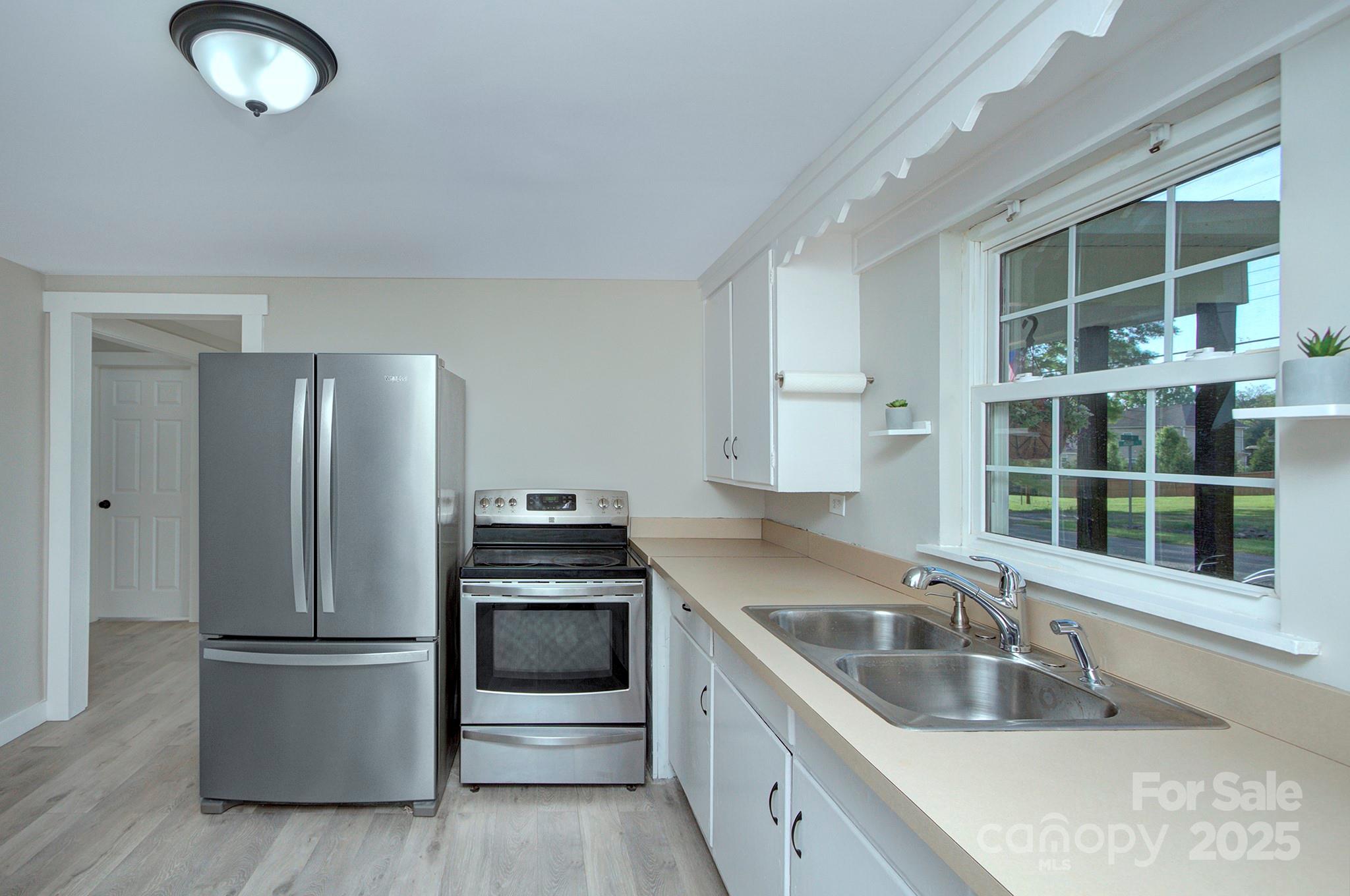103 Moore Avenue Mount Holly, NC 28120 - Photo 7 of 21 a kitchen with a sink stainless steel appliances and cabinets