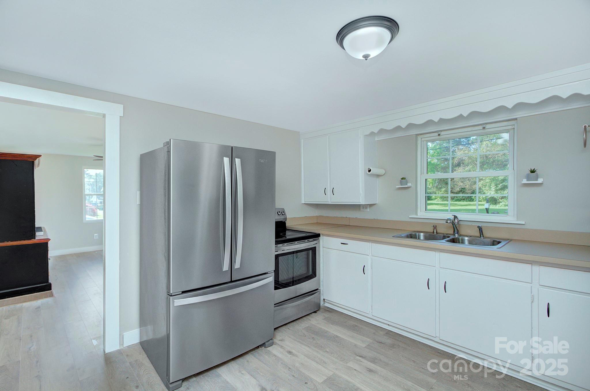 103 Moore Avenue Mount Holly, NC 28120 - Photo 8 of 21 a kitchen with a sink stainless steel appliances and window