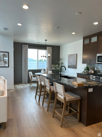 2011 West 1150 South, Unit 1042 Payson, UT 84651 - Photo 10 of 39 Photos are of model home.Spacious open-concept living area featuring a large kitchen island with a dark granite countertop, wood-finish flooring, recessed lighting, and dark wood cabinetry with frosted glass accents