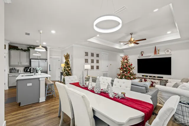 a living room with stainless steel appliances furniture a kitchen view and a flat screen tv