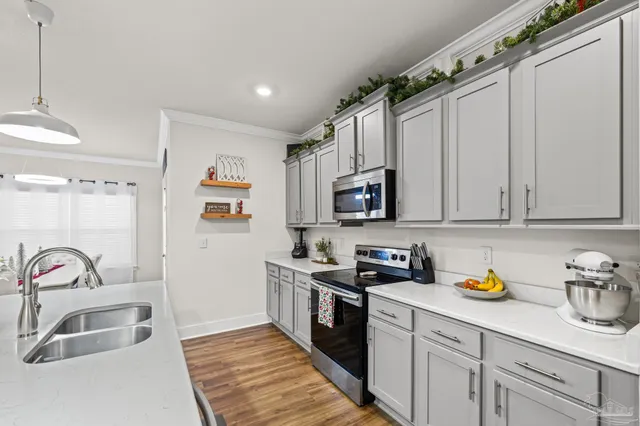 a kitchen with stainless steel appliances granite countertop a sink a stove and a refrigerator