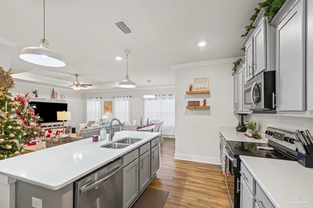 a kitchen with a sink stove and wooden floor