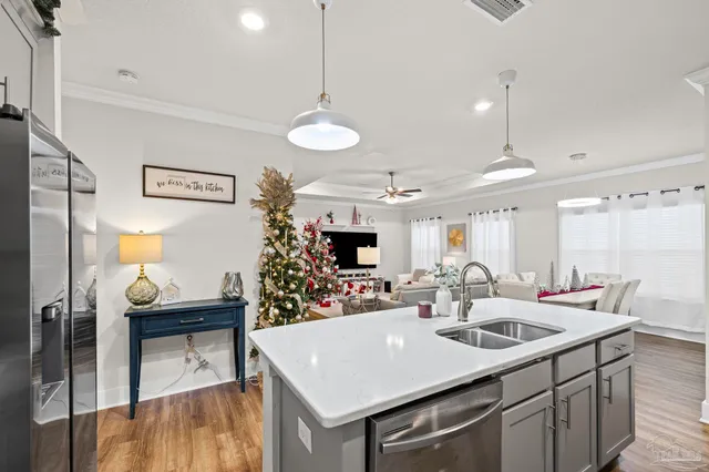 a kitchen with a sink a counter space and living room view