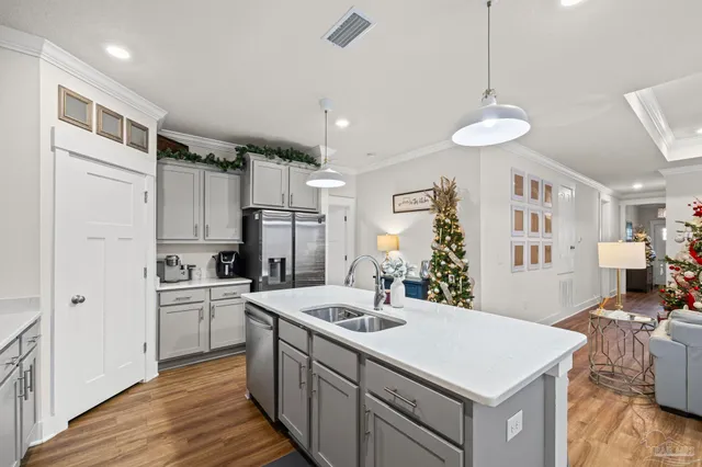 a kitchen with stainless steel appliances a sink a stove a refrigerator cabinets and living room view