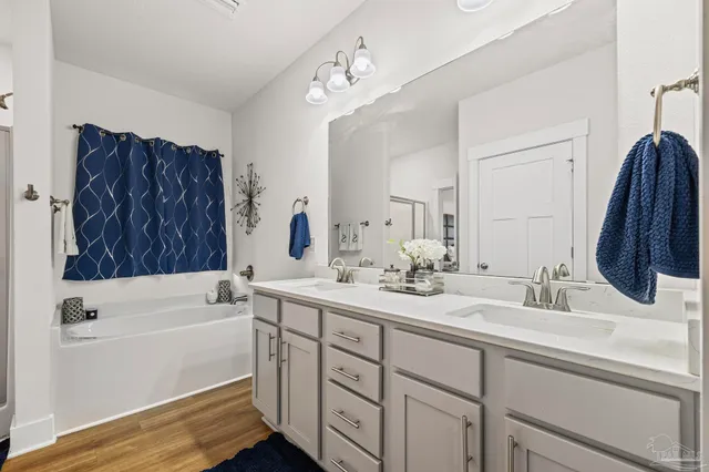 a bathroom with a tub sink and mirror