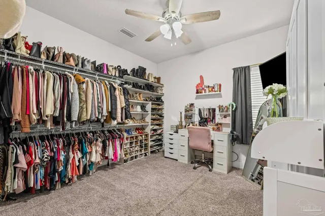 a view of walk in closet with clothes and shoes