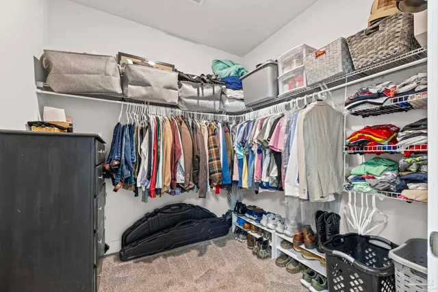 a view of walk in closet with clothes and shoes
